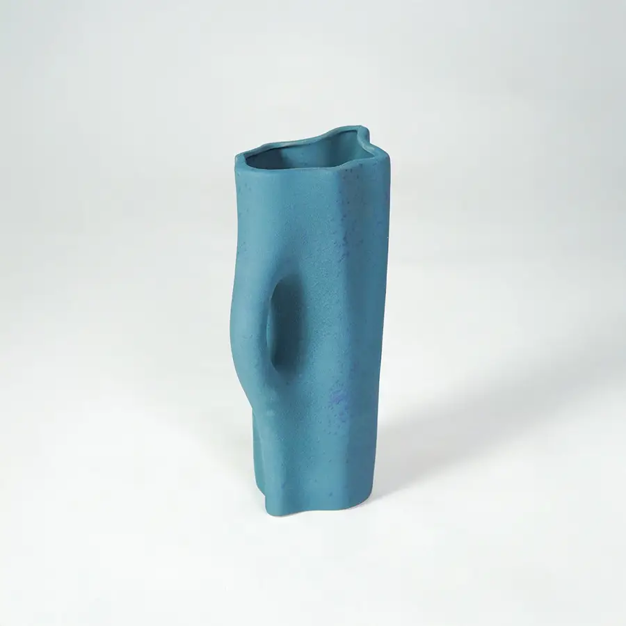 White background image of blue ceramic decorative vase for elegant shelf placement with textured matte finish.