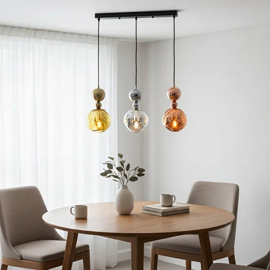 Mixed metallic glass pendant lights creating elegant ambience above the dining table in modern interiors.