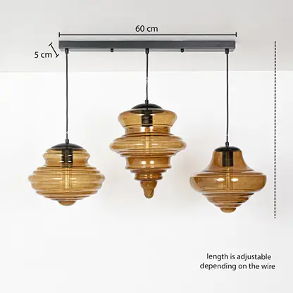 Three amber ribbed glass pendant lights on a metal canopy creating stylish linear lighting for dining room spaces.