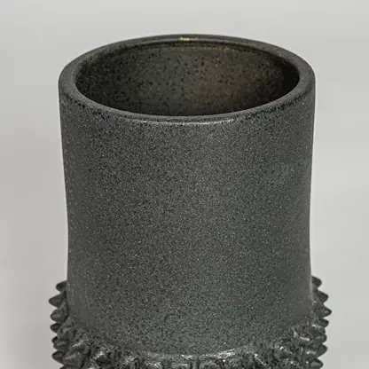 Black ceramic planter vase closeup with textured finish modern decorative pot for shelf console home decor styling.