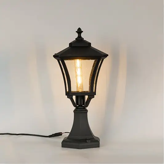 Vintage black outdoor gate light with warm glowing bulb for elegant exterior decor styling use.